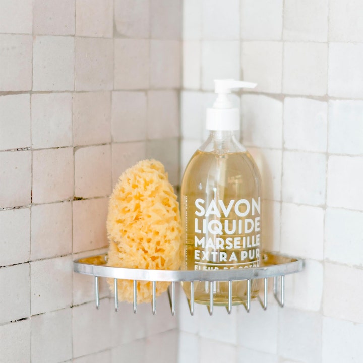 Compagnie de Provence Liquid Marseille Soap 495 ml lyxig handtvål med bomullsblomma i glasflaska bredvid en natursvamp.