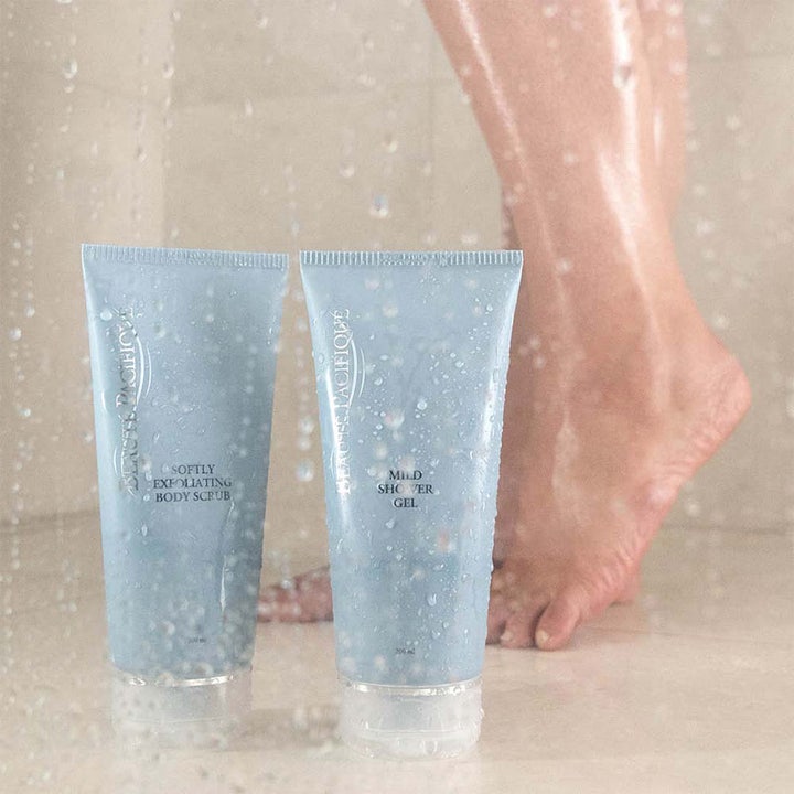 Beauté Pacifique Mild Shower Gel 200 ml lugnande duschtvål för torr hud i ljusblå tub täckt av vattendroppar i en dusch.
