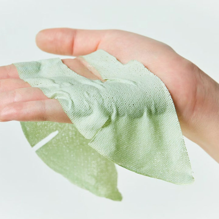 Dr.Jart+ Dermask Pore-remedy Purifying Mud Mask 13 g ansiktsmask för pormaskar med grön lera i arkform hålls i en hand.
