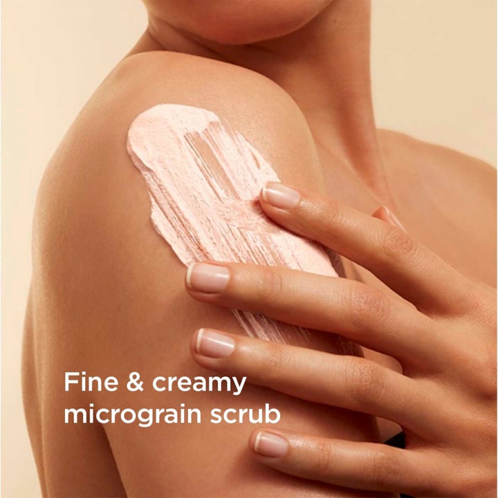 Clarins Exfoliating Body Scrub 200 ml ger mjuk hud med en krämig rosa kornpeeling som appliceras på en axel.