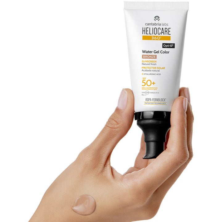 Heliocare Water Gel Color 50 ml färgat solskydd 50 i vit tub med pump och en klick tonad kräm på en hand