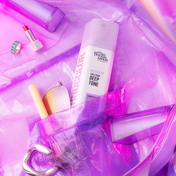 Bondi Sands Technocolor Face Serum Magenta 50 ml brun utan sol ansikte i en skimrande lila väska med accessoarer.