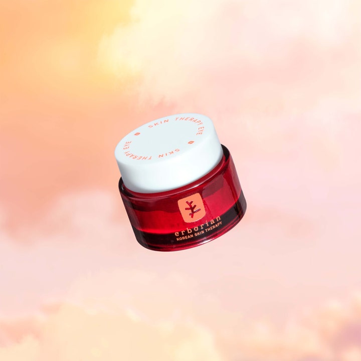 Erborian Skin Therapy Eye 15 ml koreansk ögonkräm mot mörka ringar i röd glasburk framför rosa moln.