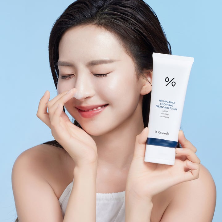 Dr. Ceuracle Pro Balance Soothing Cleansing Foam 150 ml balancerande ansiktsrengöring i vit tub som hålls av kvinna med skum.