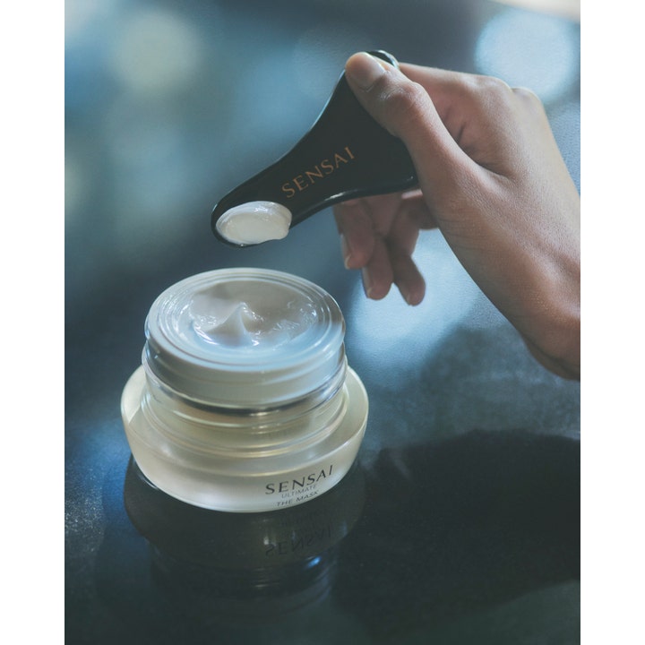 Sensai Ultimate The Mask 75 ml anti-age fuktmask för torr hud med krämig vit textur på en svart spatel