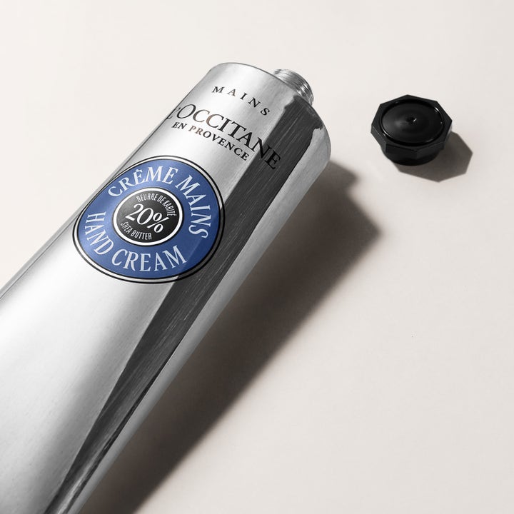L'Occitane Shea Butter Hand Cream 150 ml för torr hud i silverfärgad tub med öppet svart lock.