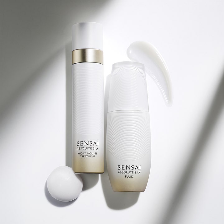 Sensai Absolute Silk Fluid 80 ml återfuktande ansiktskräm i vit flaska med guldiga detaljer och krämig textur