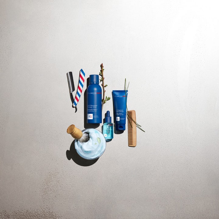 Clarins Clarins Men Shave Gel 150 ml gel för rakning visas med blå tuber, rakkniv och en skål med fylligt rakskum herr.