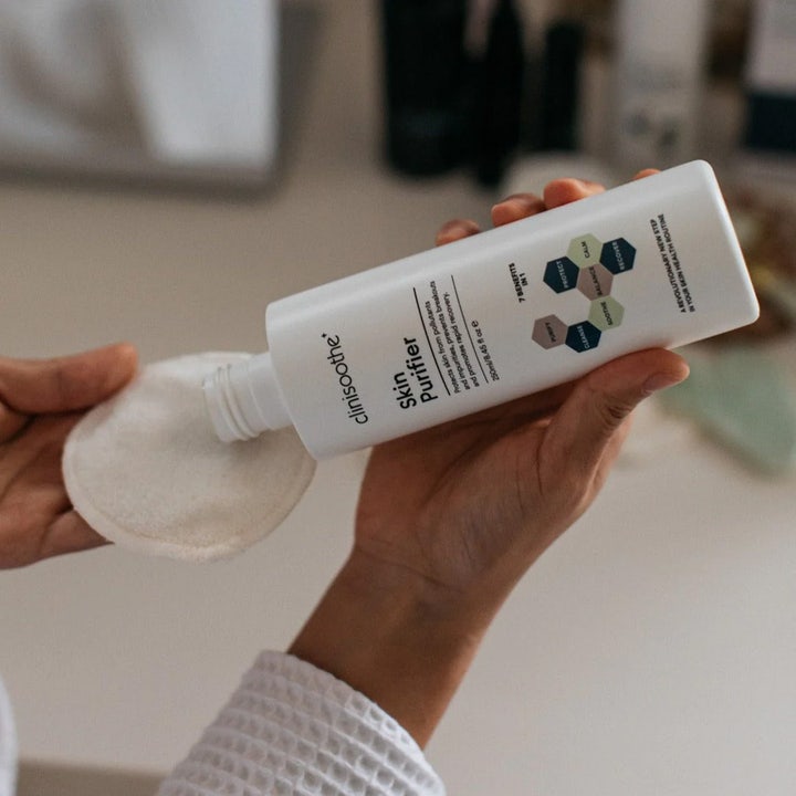 Clinisoothe Skin Purifier 250 ml ansiktsvatten toner hälls på en bomullsrondell för att motverka akne.