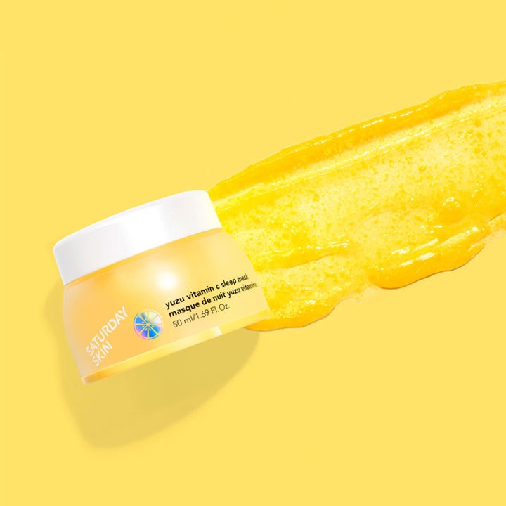 Saturday Skin Yuzu Vitamin C Sleep Mask 50 ml nattkräm som ger lyster med en kornig gul gel-textur bredvid burken.