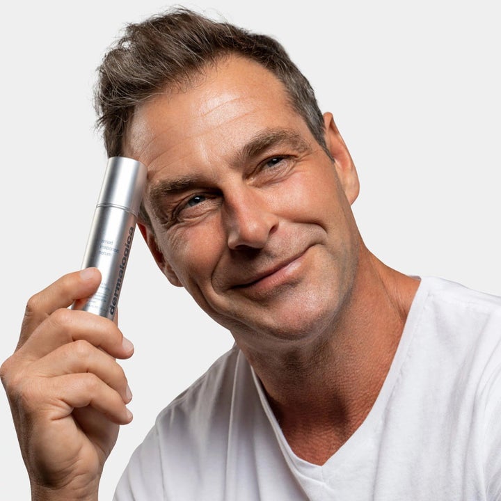 Dermalogica Smart Response Serum Duo lystergivande hudvård som hålls av en leende man