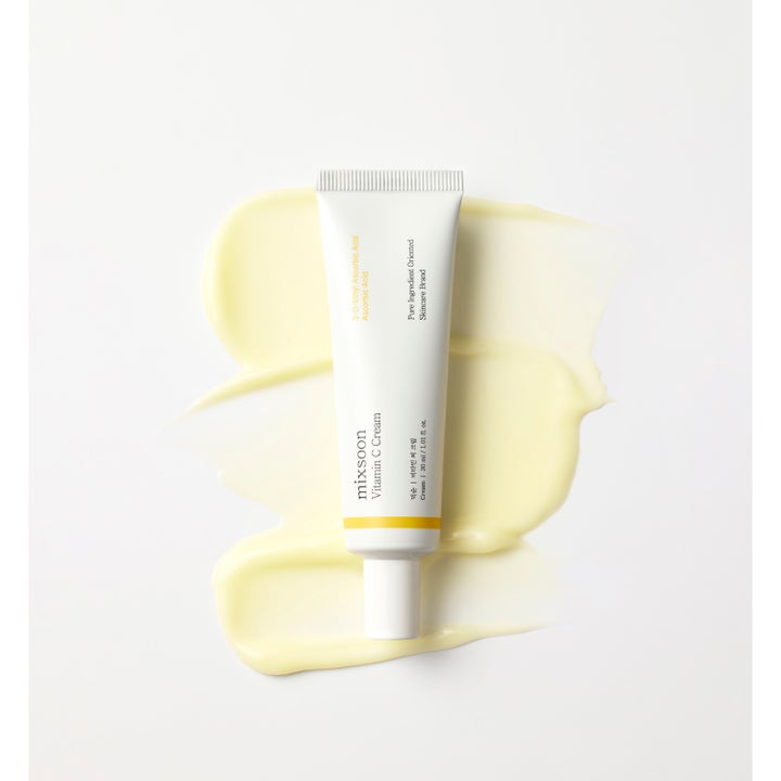 Mixsoon Vitamin C Cream 30 ml lystergivande ansiktskräm i vit tub liggandes på krämiga ljusgula texturprover.
