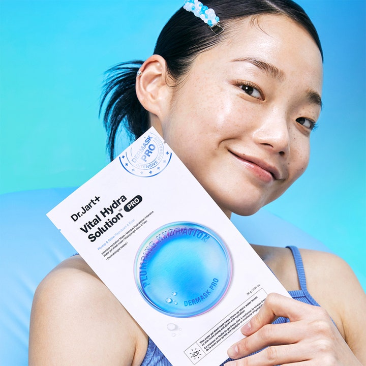 Dr.Jart+ Dermask Vital Hydra Solution Pro 26 g återfuktande sheet mask hålls av en kvinna med lyster i huden