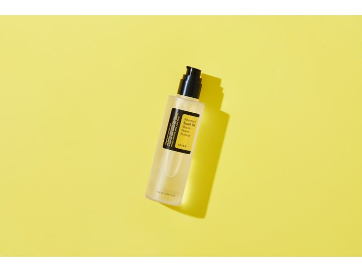 COSRX Advanced Snail 96 Mucin Power Essence 100 ml hudreparation essence i klar pumpflaska mot gul bakgrund