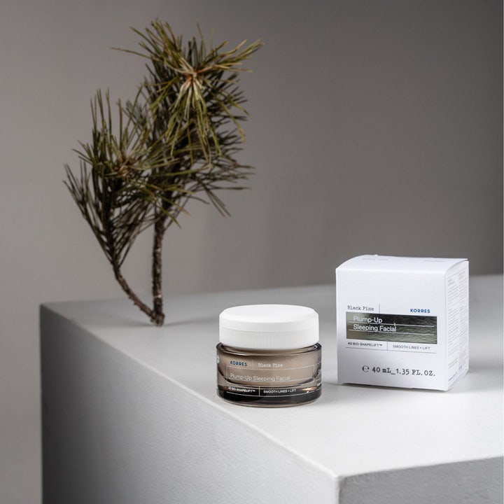 KORRES Black Pine Plump-Up Sleeping Facial 40 ml nattkräm för intensiv rynkreducering i mörk glasburk bredvid tallkvist