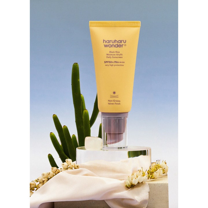 Haruharu Wonder Black Rice SPF50 50 ml fuktgivande solkräm ansikte i gul tub med lila pump ger sammetslen finish.