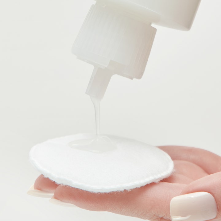Mario Badescu Hydrating Glow Toner 236 ml återfuktande ansiktsvatten med PHA som hälls på en vit bomullsrondell.