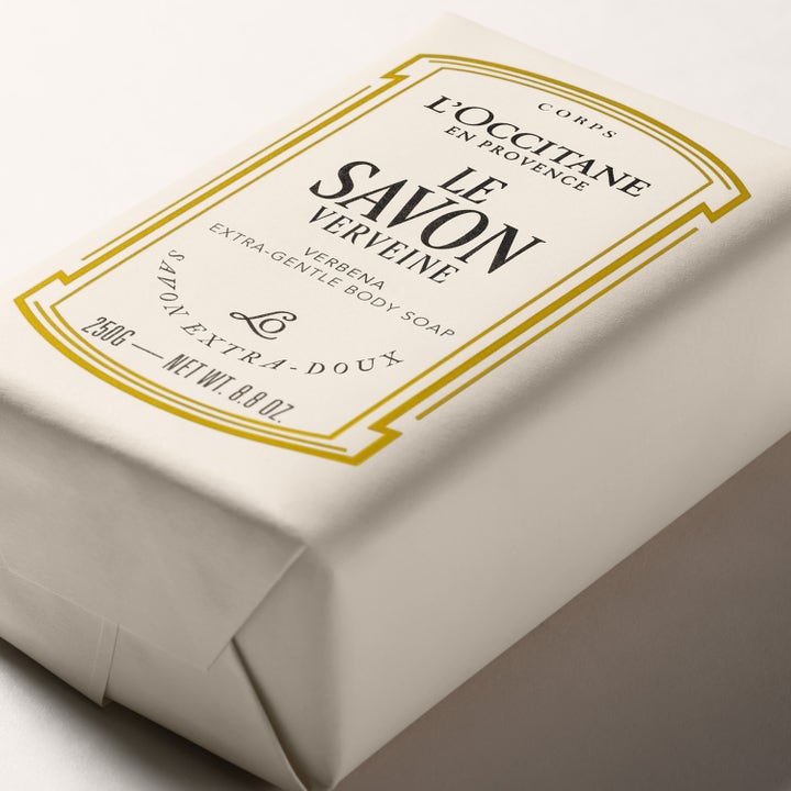 L'Occitane Shea Butter Verbena Body Soap 250 g är en vårdande fast tvål i krämfärgat pappersomslag med gulddetaljer.