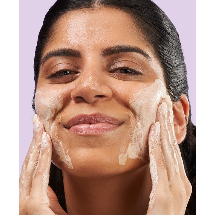 Exuviance 3-1 Clarifying Cleanser 212 ml ansiktsrengöring för porrensning 3 i 1 som löddrar på en leende kvinna