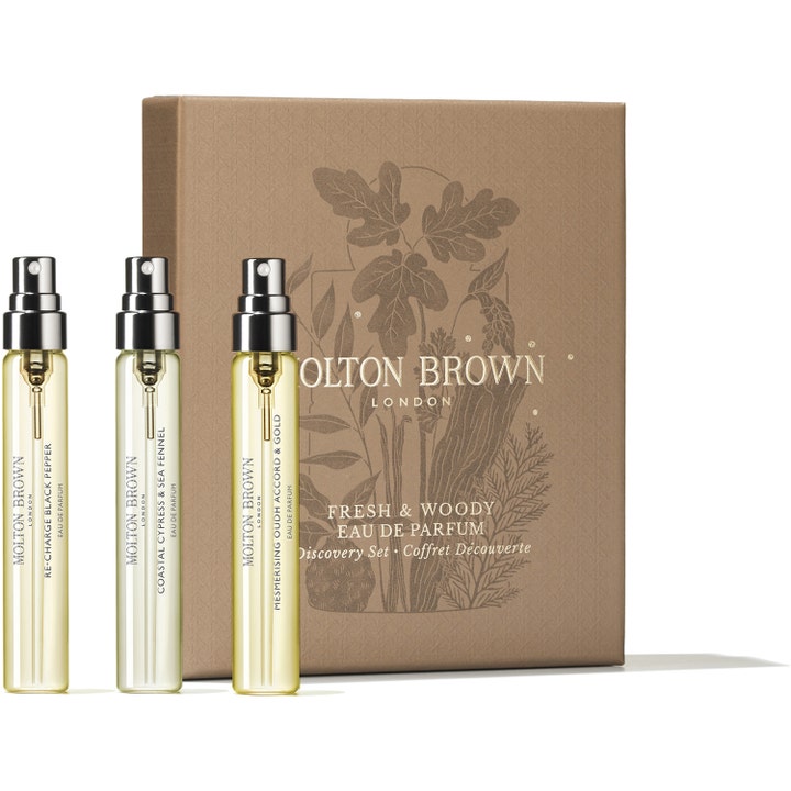 Molton Brown Woody & Aromatic Discovery Set 22,5 ml träig parfymkollektion med tre glasflaskor framför en brun ask