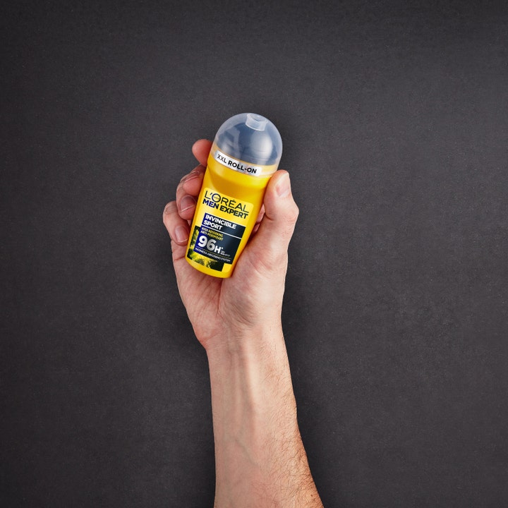 L'Oréal Paris Men Expert Invincible Sport 50 ml herrdeodorant ger 96H skydd i gul roll-on som hålls i en hand.