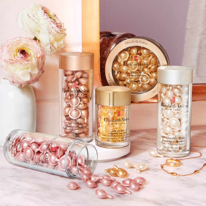 Elizabeth Arden Advanced Ceramide Capsules anti aging serum i glasburkar bredvid blommor och smycken