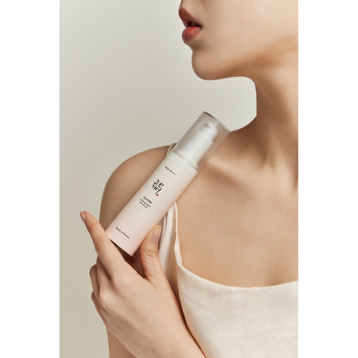 Beauty of Joseon Ginseng Moist Sun Serum 50 ml fuktgivande solskydd ansikte i en pumpflaska som hålls mot huden