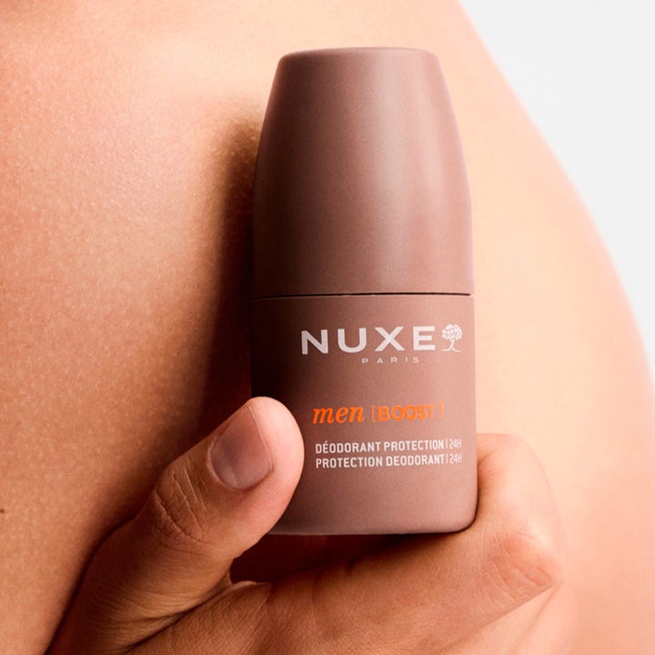 Nuxe Men 24Hr Protect Deo 50 ml herrdeodorant i brun förpackning som hålls mot huden för en fräsch känsla.