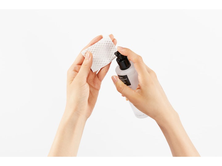COSRX BHA Blackhead Power Liquid 100 ml exfolierande toner som pumpas ut på en bomullsrondell från en frostad flaska.
