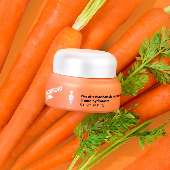 Saturday Skin Carrot + Niacinamide Moisturizing Cream 50 ml återfuktande ansiktskräm i orange burk omgiven av morötter.