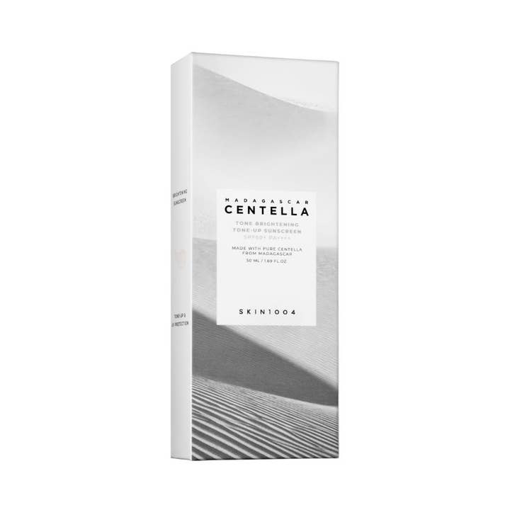SKIN1004 Madagascar Centella Tone Brightening Tone-Up Sunscreen 50 ml solskydd ansikte SPF50 ger lyster i vit ytterbox.