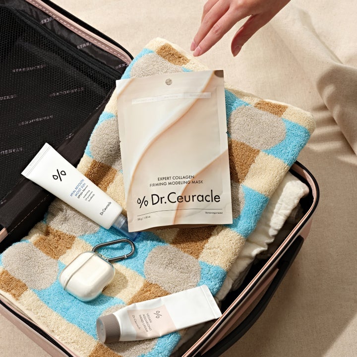 Dr. Ceuracle Expert Collagen Firming Modeling Mask 30 g i livsstilsmiljö nedpackad i en resväska.