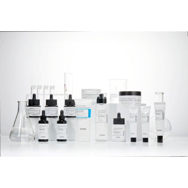 COSRX The Creamide Skin Barrier Moisturizer 80 ml ansiktskräm i vit tub bland laboratorieglas och hudvårdsserum.