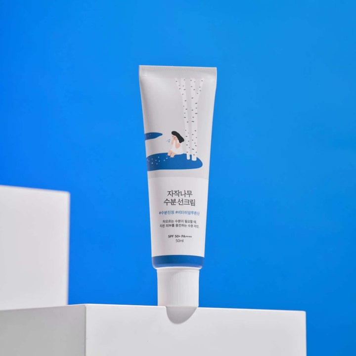 Round Lab Birch Juice Moisturizing Sunscreen 50 ml björksaft solskydd ansikte spf 50 i vit tub på ett vitt podium.
