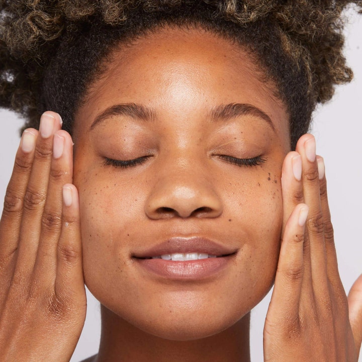 Dermalogica Sound Sleep Cocoon 10 ml återfuktande nattkräm ger lyster på en kvinna som vilar händerna mot ansiktet.