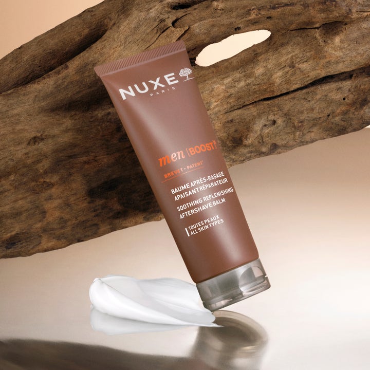 Nuxe Men Soothing Replenishing Aftershave Balm 75 ml lugnande aftershave i brun tub med krämig vit textur vid trä
