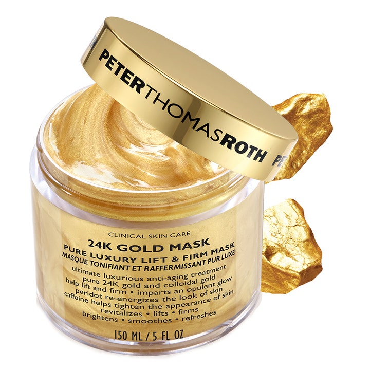 Peter Thomas Roth 24k guld uppstramande mask 150 ml med skimrande kräm i burk bredvid dekorativa guldstenar.