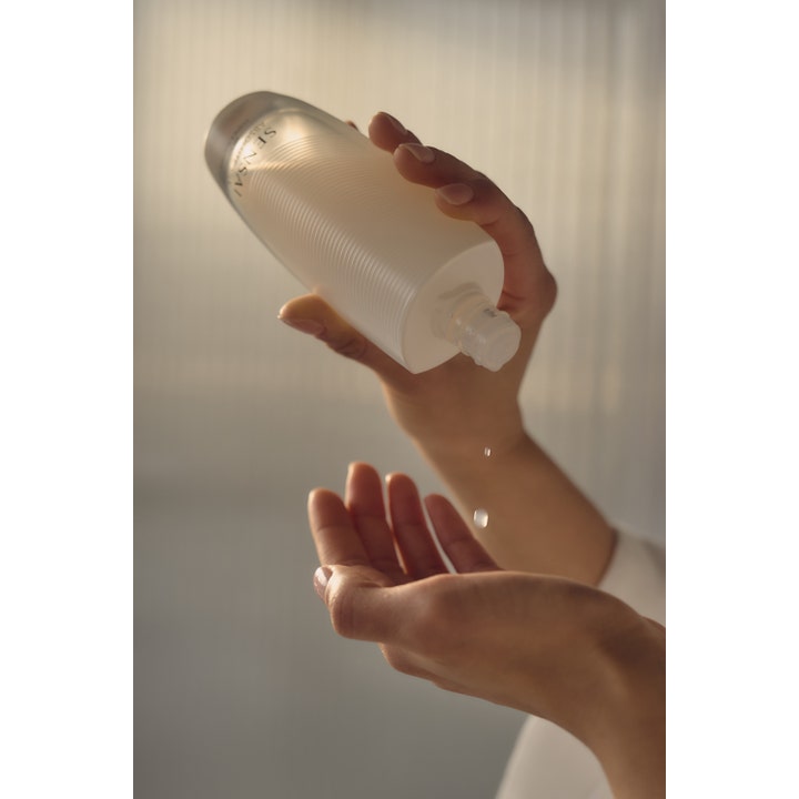 Sensai Absolute Silk Micro Essence-In-Lotion 125 ml fuktboostande hudvårdsessence droppas ur en frostad flaska i handen