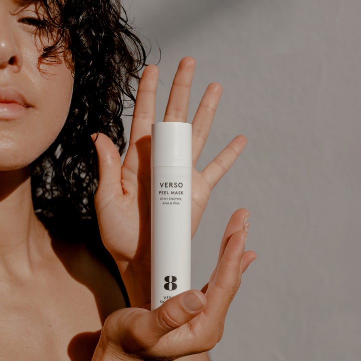 Verso N°8 Peel Mask 50 ml exfolierande ansiktsmask i vit tub som hålls upp av en person i naturligt ljus