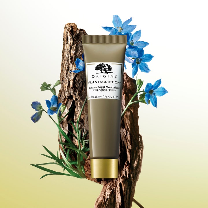 Origins Plantscription Retinol Night Moisturizer 30 ml retinol nattkräm i tub framför bark och blå blommor