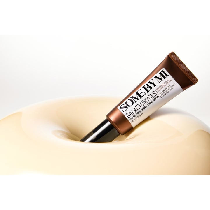 Some By Mi Galactomyces Glutathione Brightening Cream 40 ml lysterkräm i brun tub som vilar i en mjuk beige fördjupning.