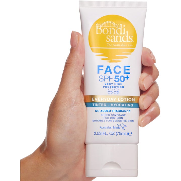 Bondi Sands Spf 50+ Everyday Face Lotion Tinted 75 ml återfuktande solkräm för ansiktet i vit tub som hålls i en hand.