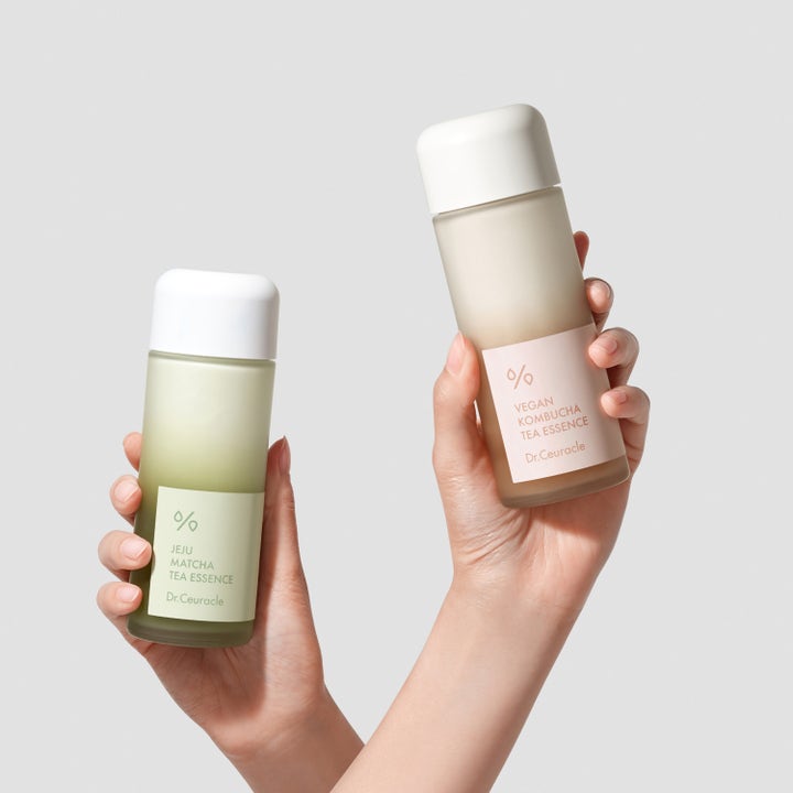 Dr. Ceuracle Jeju Matcha Tea Essence 150 ml lugnande toner i frostad flaska som hålls upp bredvid Kombucha Tea Essence.