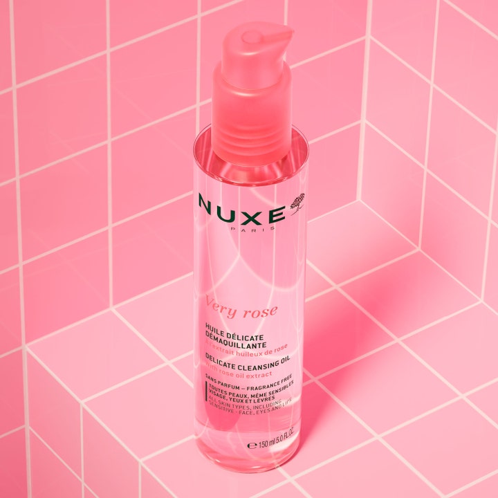 Nuxe Very Rose Cleansing Oil 150 ml rosextrakt rengöringsolja i en rosa pumpflaska på en rosa kaklad yta.