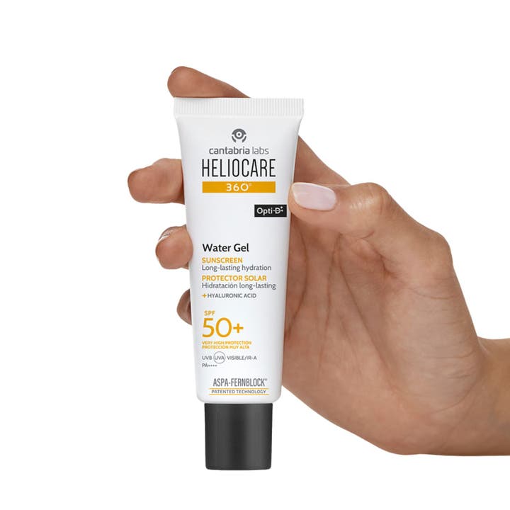 Heliocare Watergel SPF 50+ 50 ml solskyddsgel i vit tub med svart lock som hålls av en hand.