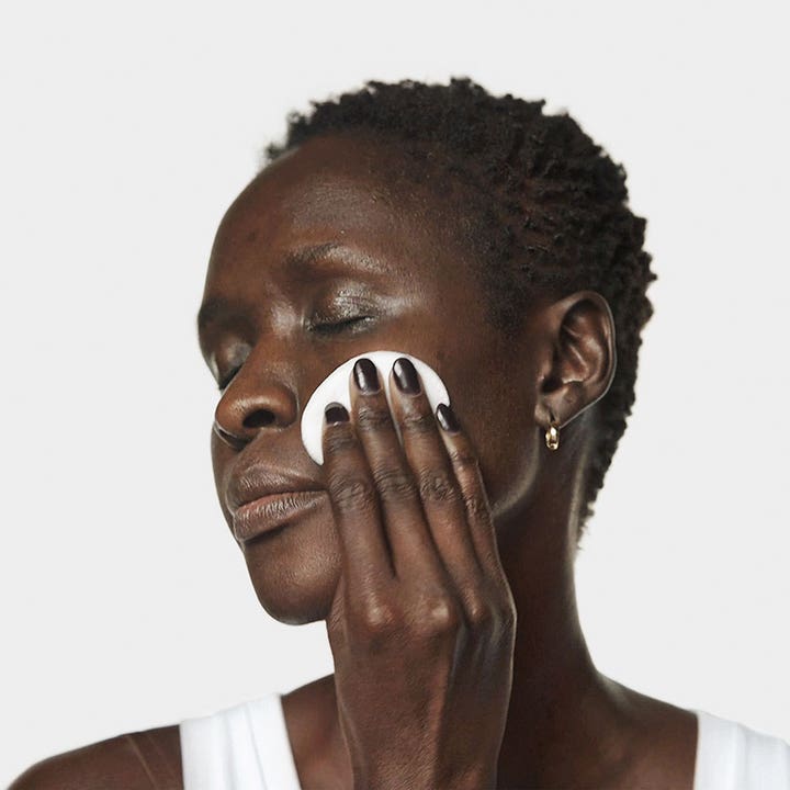 Clinique Clarifying Lotion 2 60 ml exfolierande ansiktsvatten som ger lyster visat på person med bomullsrondell