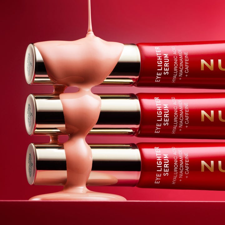 Nuxe Merveillance Lift Eye-Lighter Serum 12 ml ögonserum med hyaluronsyra och krämig rosa textur över röda tuber.