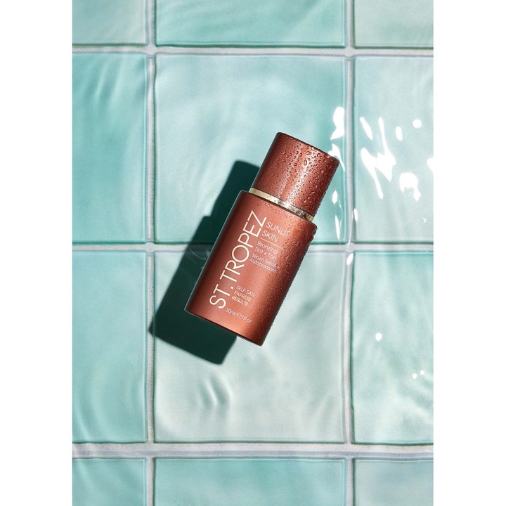 St.Tropez Self Tan Express Sunlit Skin 30 ml express flytande bronzer i bronsflaska med vattendroppar på turkost kakel.