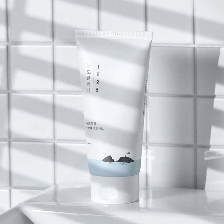 Round Lab 1025 Dokdo Cleanser 150 ml hypoallergen ansiktsrengöring i vit tub med blått motiv mot en vit kakelvägg