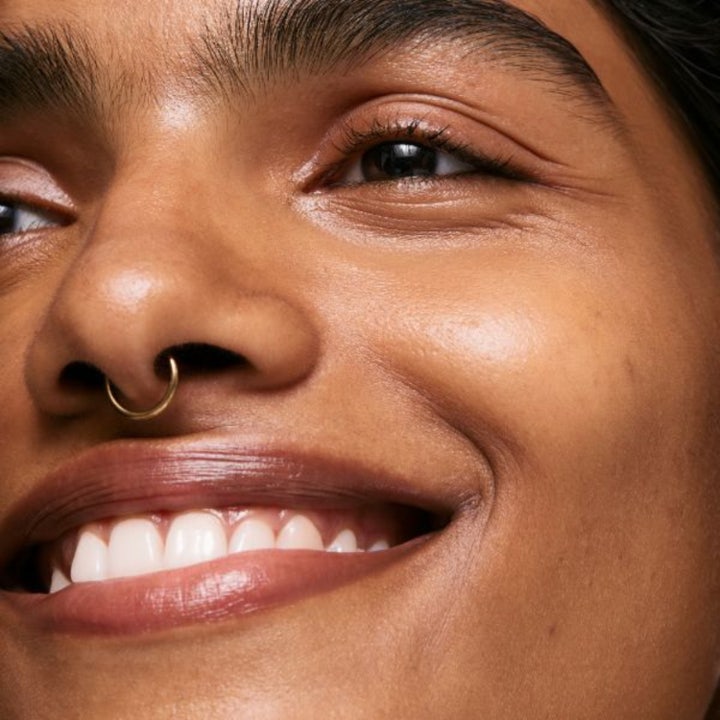 The INKEY List Brighten-i Eye Cream 15 ml illuminerande ögonkräm som ger lyster på en leende person.